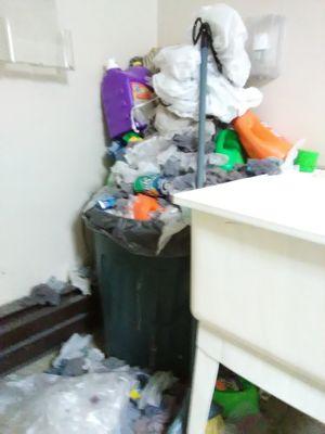 Overflowing trash can in the laundry room