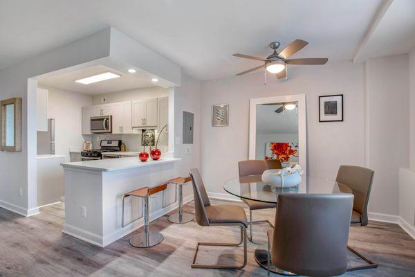 Updated kitchen with white shaker cabinets, stainless steel appliances, and backsplash and dining area