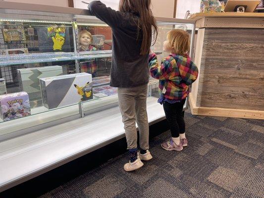 Two Pokémon fans searching the amazing cards in the display case.