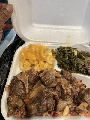 Small oxtails platter under red beans and rice, Mac and cheese, collard greens and a side of cornbread