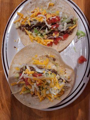 Two ground beef tacos on soft corn tortillas.