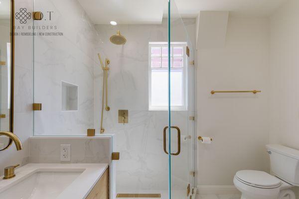 This bathroom remodel pairs modern design with classic gold fixtures, creating a space that feels both current and timeless.