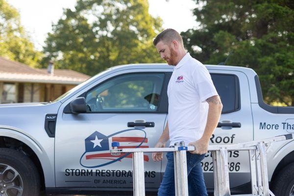 SRA Roofing & Gutters employee unloading a ladder to get ready to climb on a roof in Overland Park.