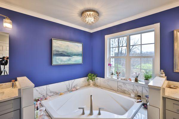 Master bathroom remodel with corner bathtub & marble lined tiles