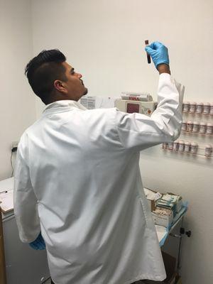 David Vazquez examining a blood specimen .