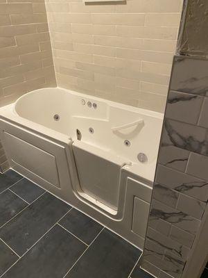 Brand new whirlpool walk-in bathtub. Also showing off shower, floor and wall tiles.