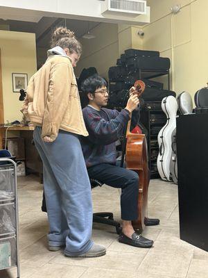 Kinichi showing my daughter how to thread her A string at the peg.