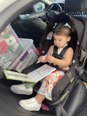 My daughter with an activity book that we picked up at Ace Pharmacy.