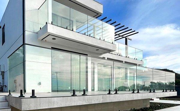 Exterior glass railing installation in Malibu -- frameless design with black spigots offering clear, unobstructed views.