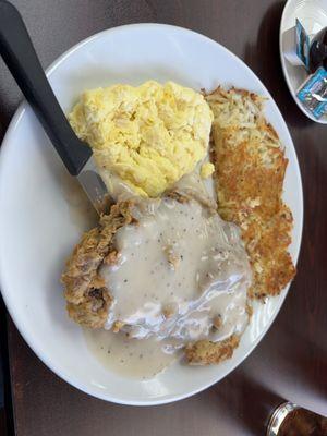 Chicken fried steak with scrambled eggs and hash browns.