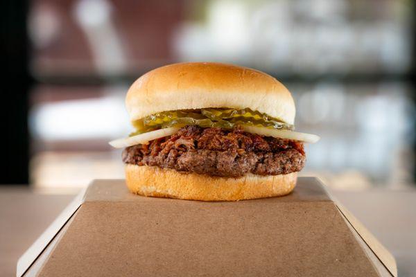 Fossil Rim Burger - BBQ Brisket on top of an all beef patty, topped with onions and pickles.