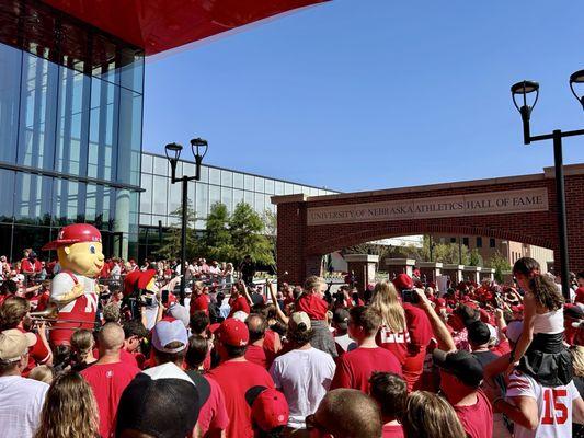 Nebraska players being welcomed through Tom Osborne Plaza.