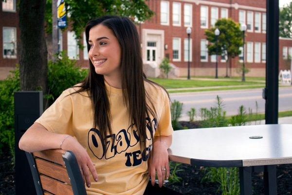 Student sitting at table on bookstore patio.
