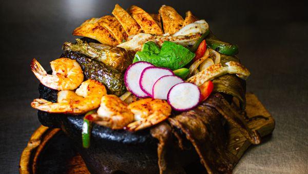 "Molcajete Oaxaqueño" -- a sizzling mix of grilled meats, shrimp, cactus, and cheese, served in a hot stone bowl. A true Oaxacan feast!