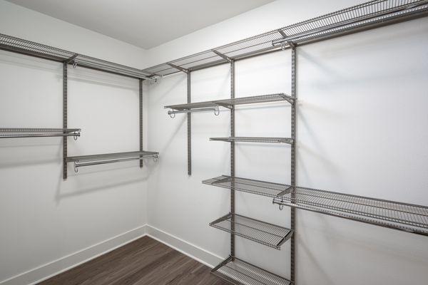 Large walk in closet with floor to ceiling industrial style clothing racks.