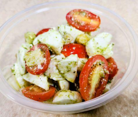 crisp grape tomatoes, creamy mozzarella, vibrant pesto, a drizzle of olive oil, and a splash of white wine vinegar.