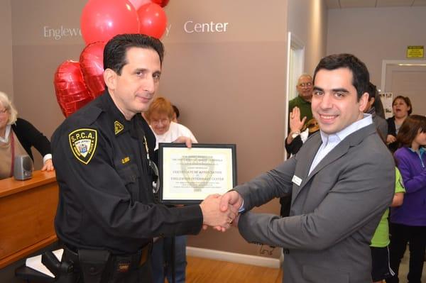 Dr. Ezik receiving N.J.S.P.C.A Certificate of Appreciation from Officer Glenn for helping pets in need.