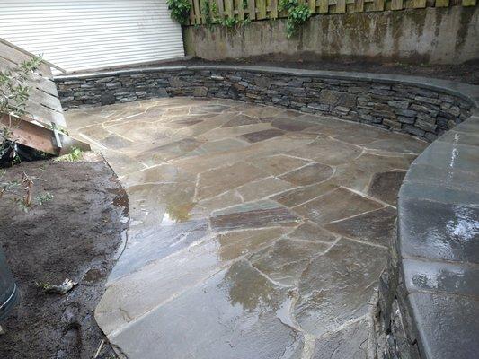 Organic bluestone patio with stone wall