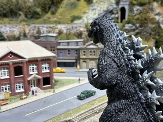 Godzilla inspecting the Model Railroad