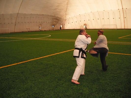 Instructor Matthew Miller with new student practicing sparring and physical fitness