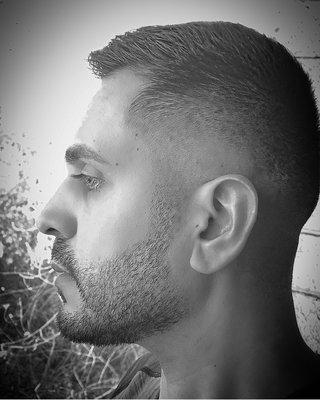 Black and white of a classic medium/high fade with short top. Barber: Jenny Cruz