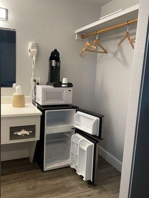 small fridge & freezer with microwave & Keurig between the end of the bathroom counter & closet area.