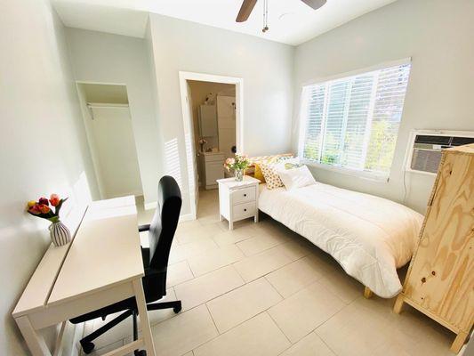 A cozy private room fully furnished for your convenience, featuring a comfortable bed, desk, and storage.