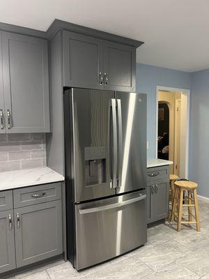 New bottom and top cabinets with crown molding all around and porcelain tile floor.