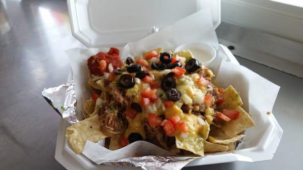 Nachos with nacho cheese made fresh daily in house, topped with a sauce of your choice, sour cream, onion, olives and fresh cut tomatoes.