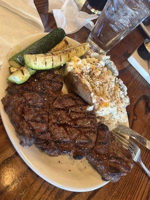 Mouthwatering Ribeye, loaded baked potato, & grilled zucchini.