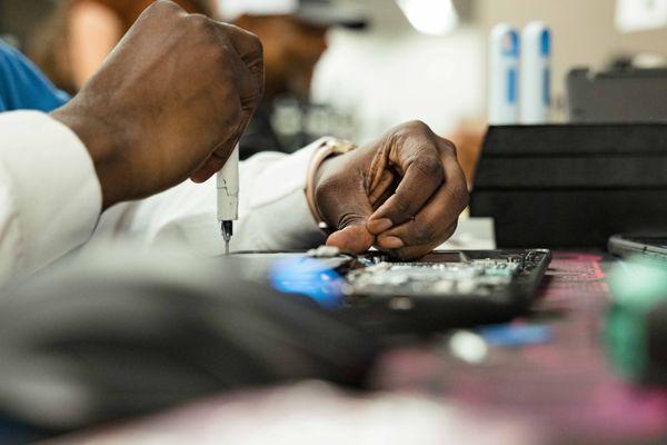 A member of the Clear Winds device repair services team repairing a Chromebook.