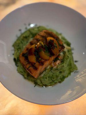 medium rare roasted salmon entrée atop confit tomato, pesto mashed potato, leek fondue