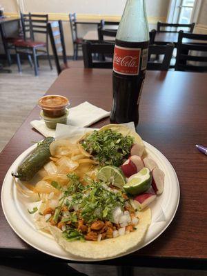 Lengua and pollo tacos with a coke. $10.