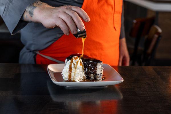 Peanut Butter Thing featuring peanut butter and chocolate chunks in ice cream, rolled in oreo and topped with sauces