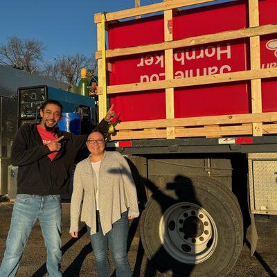 DJ and Jessie pose in front of the North Topeka office sign before it's installed
