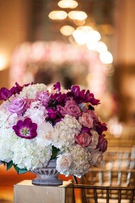 Low centerpiece on gold pillar. Photo by Min Studios