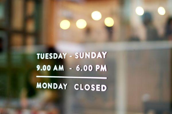 Hours signage on a bakery door