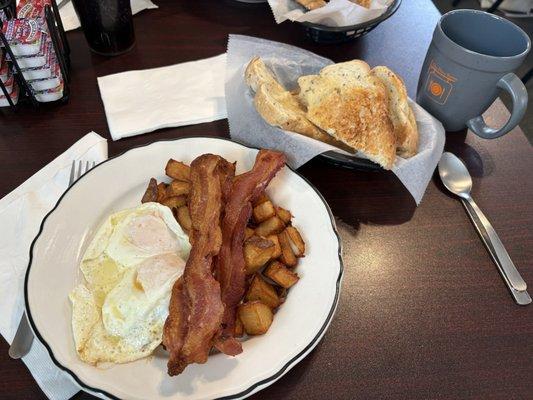 Eggs over easy, bacon, fried hash browns, and rye toast.