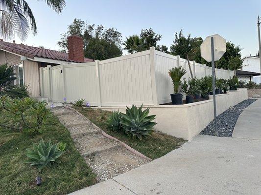 Tan vinyl fence with a gate