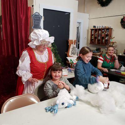 Mrs. Claus helping children with the fluff and stuff activity