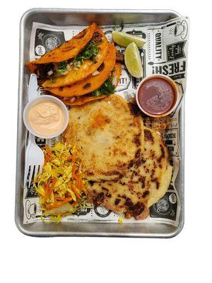 combination of quesabirrias and pupusas stuffed with pork with cheese, chipotle sauce, tomato sauce and coleslaw