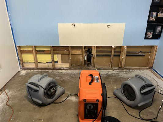 Using drying fans and air scrubbers to dry wet building materials after demolition.