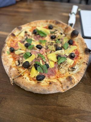 Capriccosa Pizza; red sauce, mozzarella, Prosciutto, mushrooms, black olives, artichoke hearts and fresh basil.