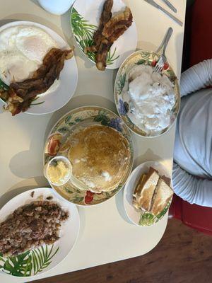 Corn beef hash, breakfast deal, country ham sandwich, biscuits and gravy with sausage, and a side of bacon.