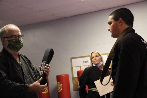 Sensei Burke receiving his Sho Dan , Black Belt, after a stellar performance!