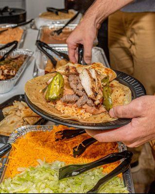 Handmade flour tortilla with juicy chicken and beef fajitas with all the fixings