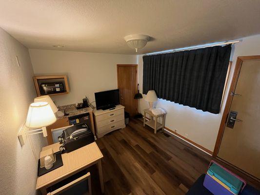 Comfortable relaxing room with broom, fridge, tv, and microwave