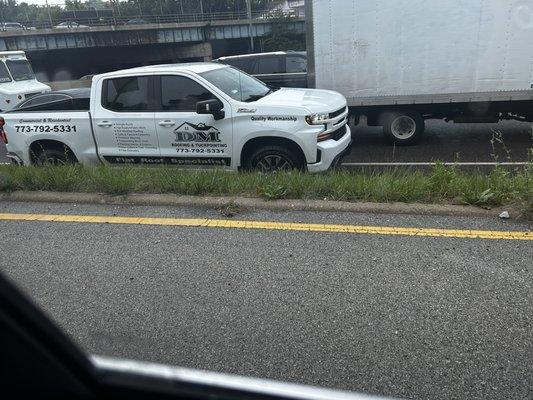 Their work truck driving in the shoulder of I90