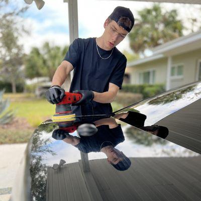Drake polishing trunk of Bullitt Mustang