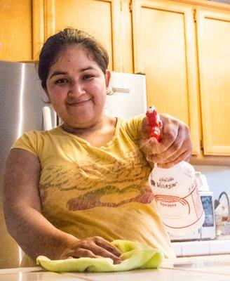 Delia using a spray bottle full of all natural product